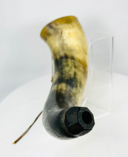 Close-up of faceted wooden stopper on an antique powder horn spout