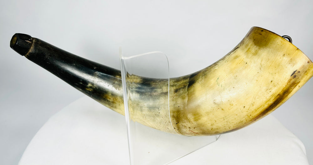 Side profile of a late 18th-century curved powder horn with original hardware