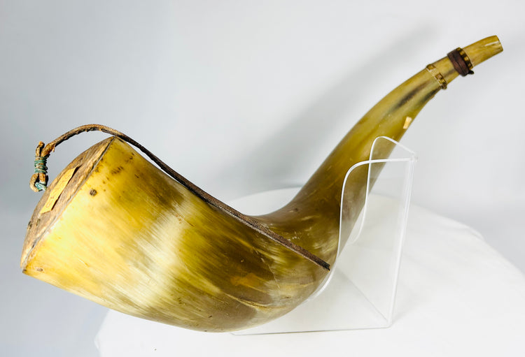 Flintlock-era priming horn showing carved initials on horn surface