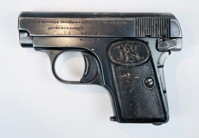 Belgian FN Browning Model 1906 with stamped slide lettering, a curved trigger, and a textured FN-monogram grip.