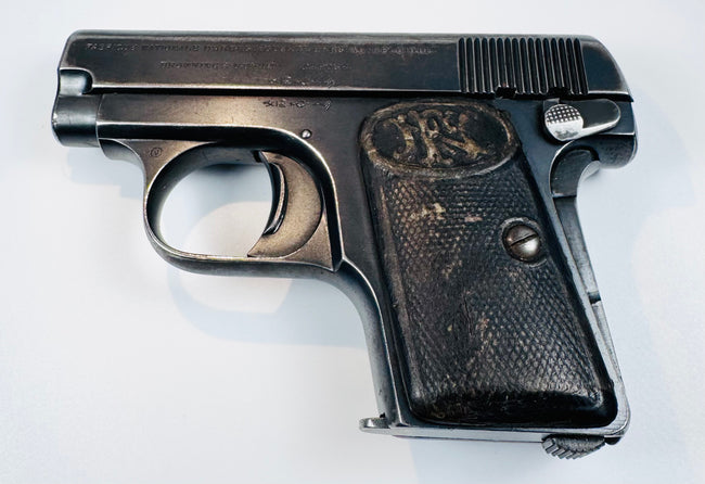 FN Browning Model 1906 Triple Safety variant with an enlarged manual safety lever, slide serrations, and checkered grips.