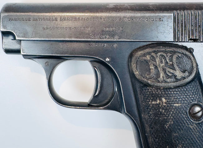 FN Browning Model 1906 displaying stamped slide inscriptions above the curved trigger guard and worn checkered grip.
