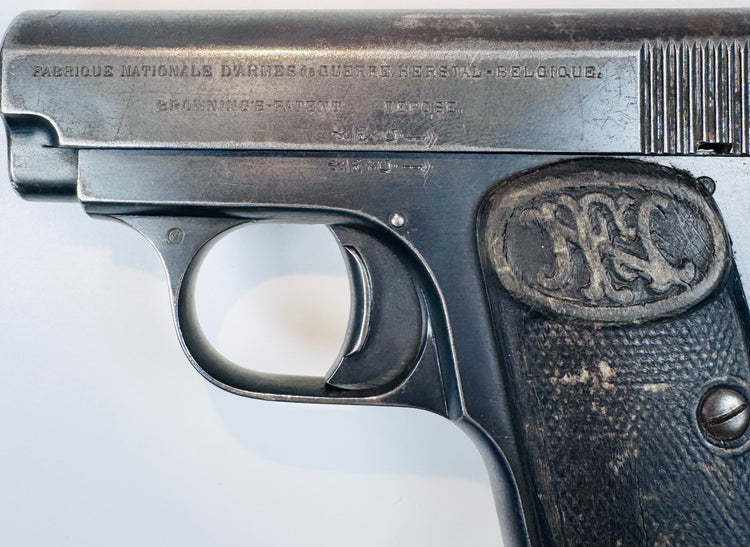 FN Browning Model 1906 displaying stamped slide inscriptions above the curved trigger guard and worn checkered grip.