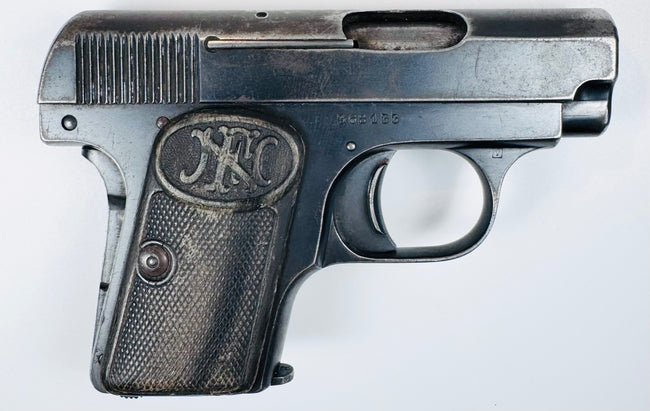Belgian Browning Model 1906 featuring an oval ejection port, curved trigger, and age-worn checkered grip panel.