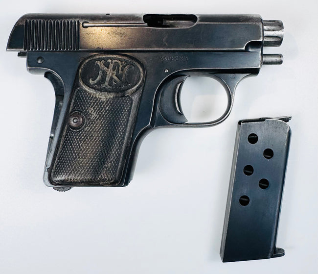 FN Browning Model 1906 displayed with its detached magazine, checkered grip, oval FN emblem, and visible ejection port.