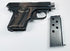 Browning Model 1906 pocket pistol beside a detached metal magazine with circular inspection holes.