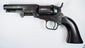 Colt Model 1849 Pocket Revolver with a four-inch octagonal barrel, five-shot cylinder, and curved walnut grip.
