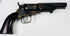 Antique Colt Model 1849 Pocket Revolver with an exposed hammer, worn steel cylinder, and warm-toned brass trigger guard.