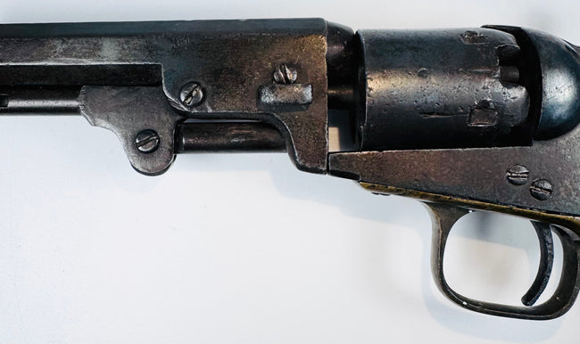 Colt Model 1849 Pocket Revolver detail featuring the barrel wedge, frame screws, cylinder, and age-worn steel surfaces.