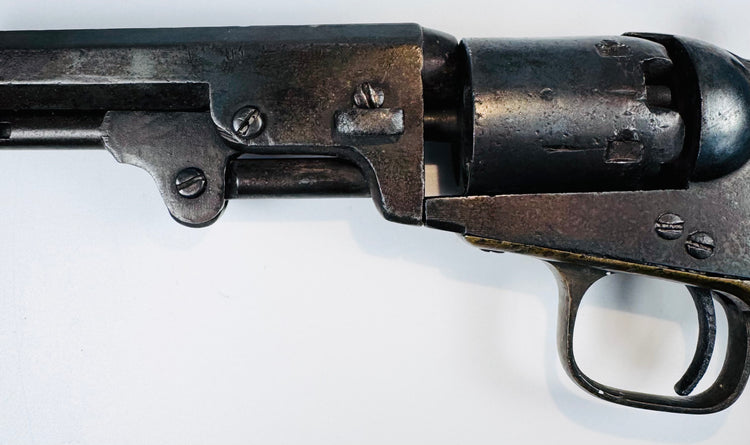 Colt Model 1849 Pocket Revolver detail featuring the barrel wedge, frame screws, cylinder, and age-worn steel surfaces.