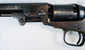 Colt Model 1849 Pocket Revolver detail featuring the barrel wedge, frame screws, cylinder, and age-worn steel surfaces.