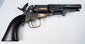 Colt Model 1849 Pocket Revolver showing its exposed hammer, silvered cylinder wear, and loading lever resting beneath the barrel.