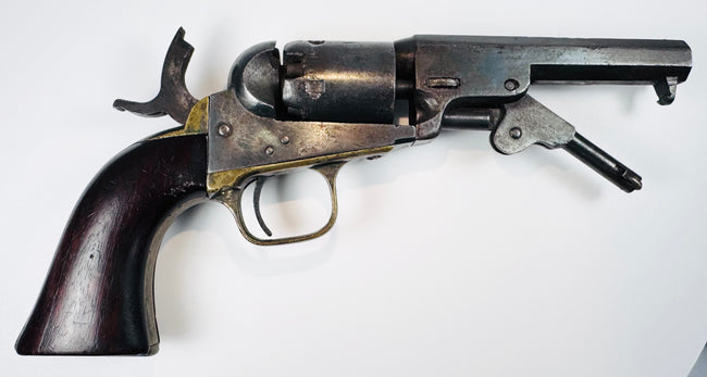 Colt Model 1849 Pocket Revolver with an extended loading lever, aged brass trigger guard, and varnished walnut grip.
