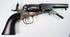 Colt Model 1849 Pocket Revolver with an extended loading lever, aged brass trigger guard, and varnished walnut grip.