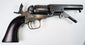 Colt Model 1849 Pocket Revolver with an extended loading lever, aged brass trigger guard, and varnished walnut grip.