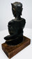 Shan-style bronze Buddha showing the crown’s flared edges, curved shoulders, and dark patina across its back.