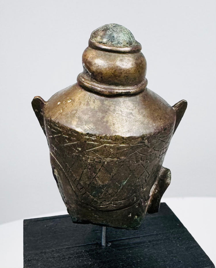 Southeast Asian Buddha head sculpture with serene facial features and textured aged metal