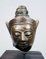 Antique Southeast Asian Buddha sculpture with meditative expression and decorative headdress
