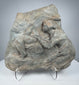 Ancient Roman carved stone relief depicting two Classical figures in deeply weathered volcanic tuff