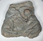 Roman volcanic tuff fragment with raised figural carving, irregular ancient-style edges and aged surface deposits