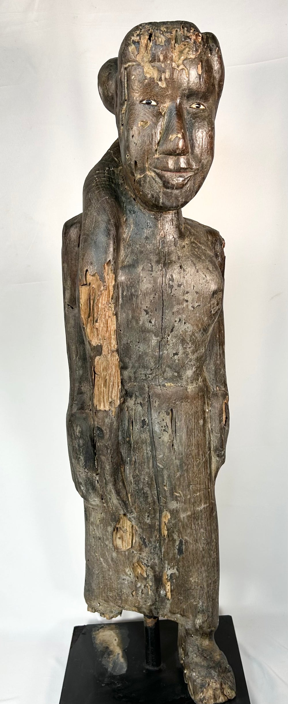 Hand-carved Dayak ancestral figure with inset eyes and aged surface