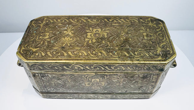 Front exterior of an antique Mindanao betel box showing engraved floral decoration, brass inlay, and rectangular form.