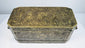 Front exterior of an antique Mindanao betel box showing engraved floral decoration, brass inlay, and rectangular form.