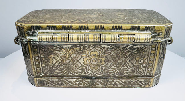 End profile of an antique Filipino betel box showing the raised lid, decorative metalwork, and side-mounted suspension ring.