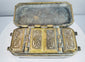 Interior of an antique Mindanao buyo box showing four decorated compartment lids arranged within the fitted metal case.