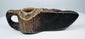 Carved stone oil lamp from the early Islamic world featuring a compact form and symmetrical decorative patterns.