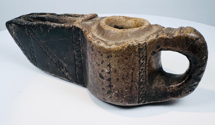 Ancient carved stone lamp from the Islamic world with geometric detailing and a projecting spout designed for a wick.