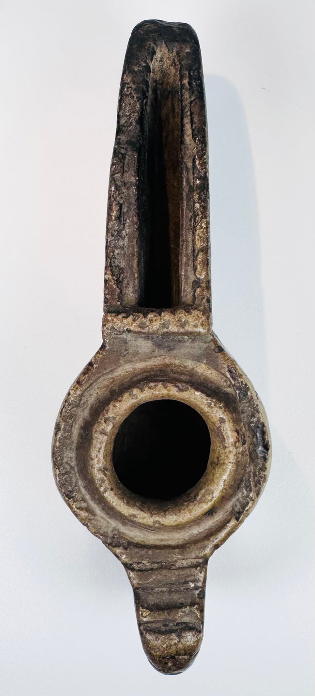 Hand-carved Middle Eastern stone lamp with abstract geometric decoration and an elongated spout for burning oil.