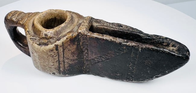 Early medieval Islamic stone oil lamp with geometric ornamentation, functional wick opening, and historic patina.