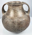 Early Etruscan impasto amphora with twin loop handles, flared rim, rounded body, and large incised spiral motifs across the front.