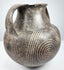 Early Etruscan amphora showing both handles, broad shoulder, and radiating geometric decoration between the large spiral motifs.