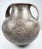 Upper angle of the Etruscan impasto vessel showing the open mouth, thick rim, twin handles, and incised decoration across the shoulder.
