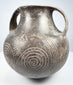 Upper angle of the Etruscan impasto vessel showing the open mouth, thick rim, twin handles, and incised decoration across the shoulder.