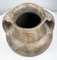 Rear-side angle of the Etruscan vessel showing both handle attachments and a large incised spiral decorating the rounded body.