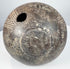 Ancient impasto amphora showing a side section with linear incisions, aged terracotta surface, and a visible vertical crack on the body.
