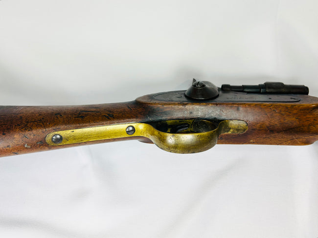 Detailed view of the Snider-Enfield brass trigger guard and steel lockplate set in a worn 19th-century walnut stock.