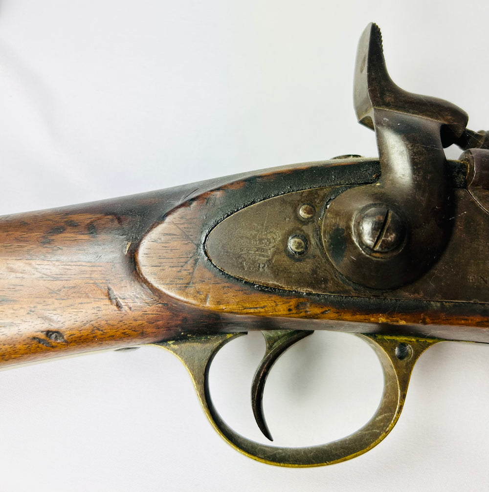 Close-up of the Snider-Enfield percussion-style hammer, trigger assembly, and engraved lockplate dated 1864.