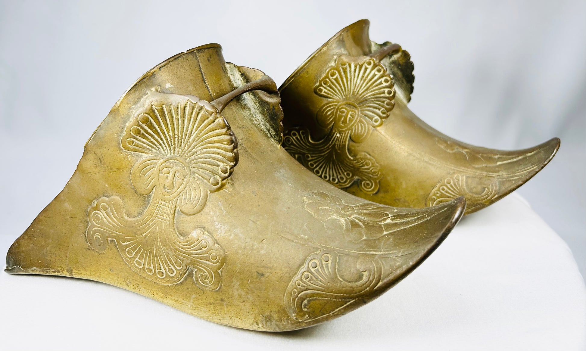 Cast brass equestrian slipper stirrups with triangular drainage openings and strap bars intact.