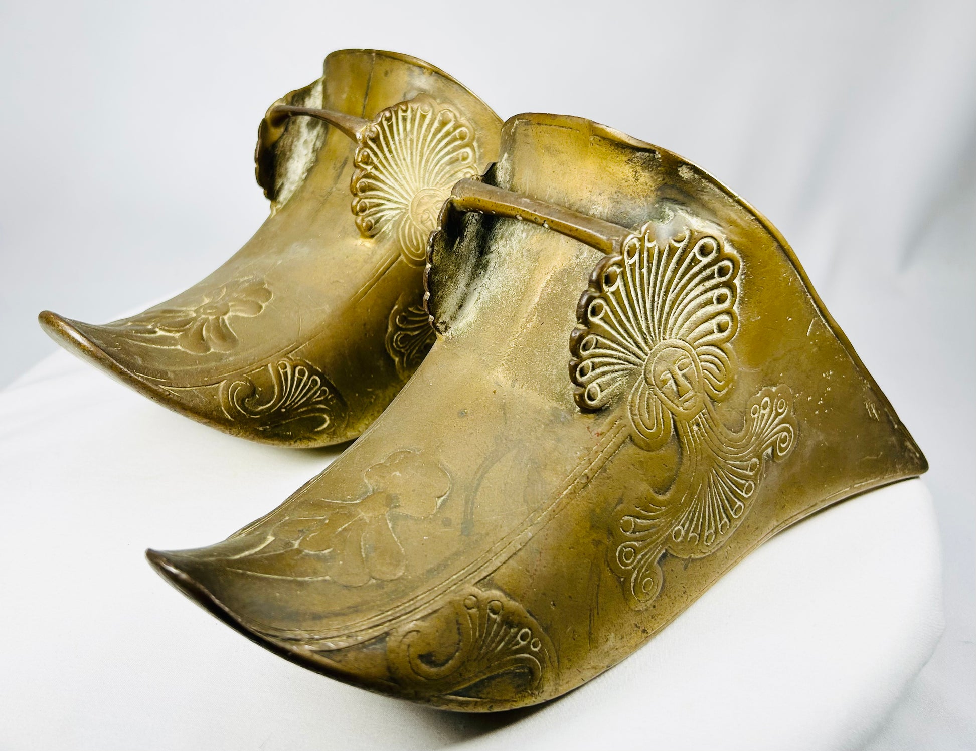 Antique equestrian brass slipper stirrups combining Colonial and Indigenous artistic influences.