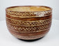 Rounded ceramic bowl with linked diamond bands and contrasting cream-colored lines.