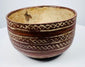 Ceramic bowl with alternating plain bands and interlocking X-shaped decoration.