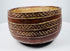 Bichrome ceramic bowl with repeating diamond motifs and visible surface wear.