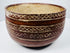 Decorated pottery bowl with cream geometric bands following its curved exterior.