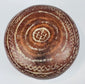 Ceramic bowl underside with concentric rings surrounding a central geometric motif.