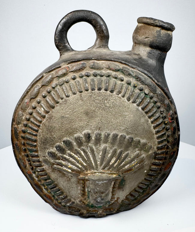 Dark-fired ceramic canteen with raised human face and feather-like ornament