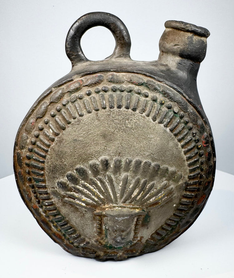 Dark-fired ceramic canteen with raised human face and feather-like ornament